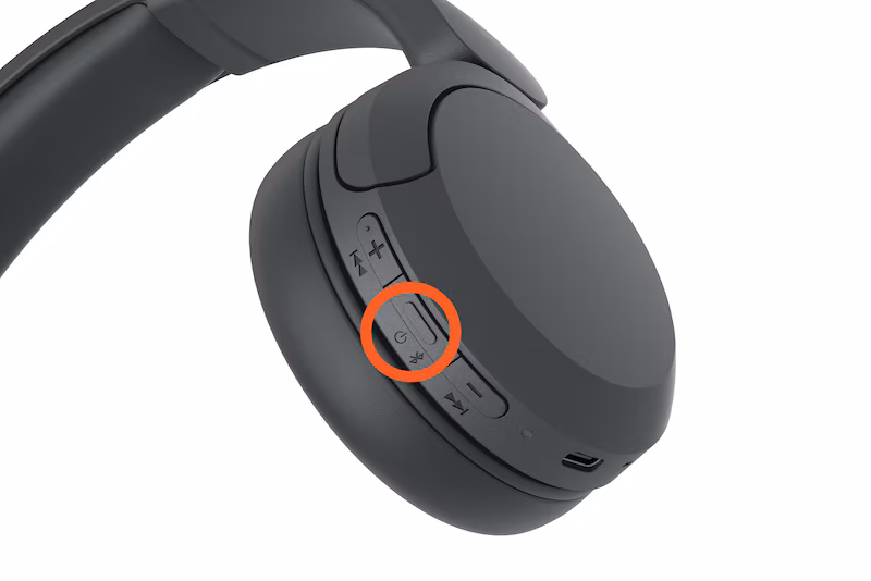 Person activating pairing mode on headphones