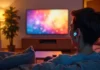 Person watching TV with wireless earbuds.