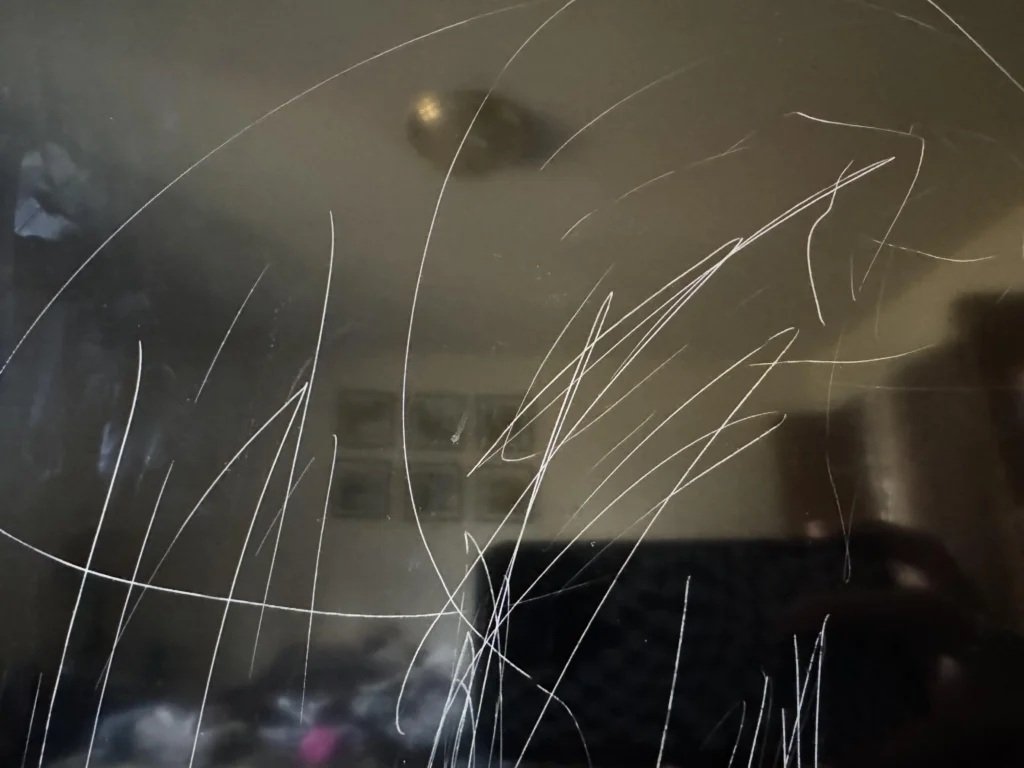 Close-up of a TV screen showing a scratch in off and on states